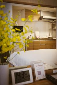 ein Zimmer mit Küche und einem Tisch mit gelben Blumen in der Unterkunft DL Shinsaibashi in Osaka + 29 Fotos