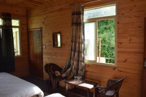 ein Schlafzimmer mit einem Bett und einem Tisch und einem Fenster in der Unterkunft The Kalp in Jāmb