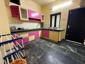 una cucina con mobili colorati e una porta nera di Bluebell Homes A - 3 BHK Near to Calicut a Beypore Altre 22 foto