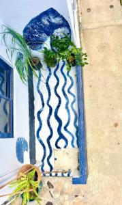 a blue and white wall with some plants on it at Kasa Gigi in El Nido