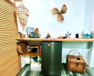 a green trash can in a room with a desk at Kasa Gigi in El Nido