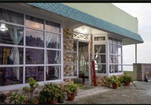 a building with windows and potted plants in front of it at Aashray kunj homestay in Jāmb