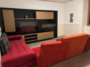 een woonkamer met twee rode stoelen en een televisie bij Le séjour in Tramelan