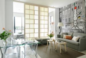 a living room with a couch and a table and chairs at Eric Vökel Boutique Apartments - Amsterdam Suites in Amsterdam