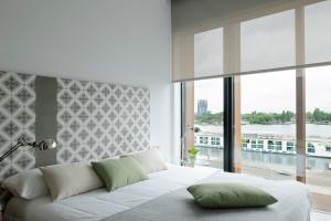 Schlafzimmer mit einem weißen Bett und einem großen Fenster in der Unterkunft Eric Vökel Boutique Apartments - Amsterdam Suites in Amsterdam