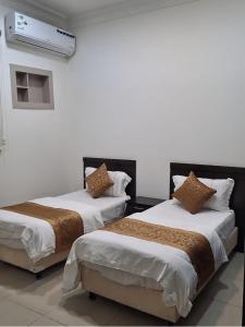 Giường trong phòng chung tại أرض الذهب للشقق المخدومة الرويضة