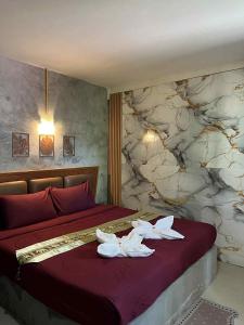 ein Schlafzimmer mit einem Bett mit weißen Handtüchern darauf in der Unterkunft Lanta natural hut garden in Phra Ae beach