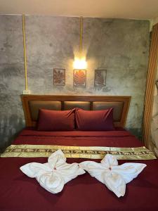 ein rotes Bett mit zwei weißen Handtüchern darauf in der Unterkunft Lanta natural hut garden in Phra Ae beach