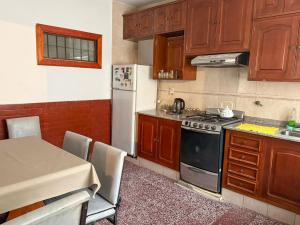 a kitchen with wooden cabinets and a stove and a table at CASA HORTENSIA in Salta