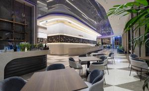 ein Restaurant mit Tischen und Stühlen und eine Bar in der Unterkunft Annova Nha Trang Hotel in Nha Trang