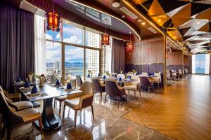 ein Restaurant mit Tischen und Stühlen und einem großen Fenster in der Unterkunft Annova Nha Trang Hotel in Nha Trang