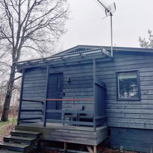 una casetta blu con portico e scale di Puisto mökki a Rauma