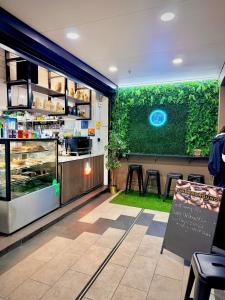 een restaurant met een groene muur met een toonbank bij Cozy Studio near Sydney Hyde Park with Rooftop Pool & FREE Parking in Sydney +33 foto's