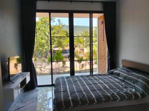 une chambre avec un lit et une grande fenêtre dans l'établissement กัสเกรซ โฮมสเตย์, à Pak Chong