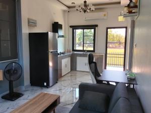 un salon avec un canapé et une table et une cuisine dans l'établissement กัสเกรซ โฮมสเตย์, à Pak Chong