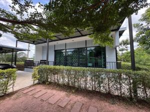 un bâtiment avec une clôture devant lui dans l'établissement กัสเกรซ โฮมสเตย์, à Pak Chong