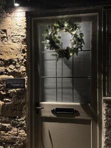 een deur met een kerstkrans erop bij Priory Weavers Cottage in Burford