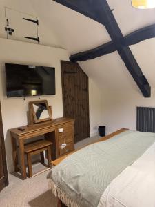 een slaapkamer met een bed en een dressoir met een spiegel bij Priory Weavers Cottage in Burford