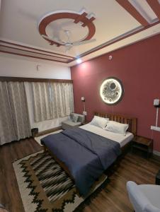 a bedroom with a large bed and a red wall at Kassy homestay in Udaipur