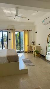 Un dormitorio con cama, escritorio y ventanas en Sjæl - Surf, Stay and yoga, en Dikwella 46 fotos más