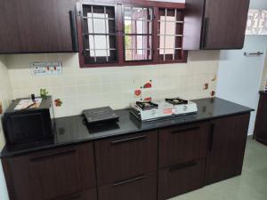 a kitchen with a stove and a microwave on a counter at Agapi Homestay in Cochin