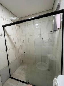 een badkamer met een glazen douche met toilet bij Casa de alto padrão in Aparecida