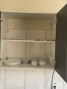 een kast met borden en borden erin bij Casa de alto padrão in Aparecida