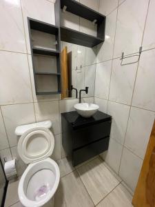 een badkamer met toilet en wastafel bij Casa de alto padrão in Aparecida