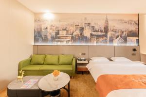 a hotel room with two beds and a green couch at Youth Innovation Apartment in Guangzhou +12 photos