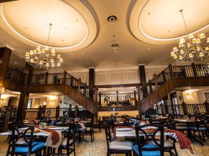 een eetkamer met tafels, stoelen en kroonluchters bij Carousel Eco Estate in Temba