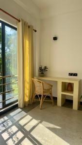 a living room with a desk and a window at Calma Cafe - Surf, Stay and Yoga in Dickwella +47 photos