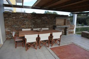 a wooden table and chairs on a patio at Afroditi-VILLA-3, private pool, sea and golf in Afantou