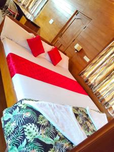 a bed with two red pillows on top of it at Mansion Du Lac in Kottayam