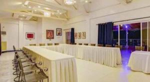 Una gran sala con mesas y sillas. en Vitalis White Sands, en Baraoas 196 fotos más