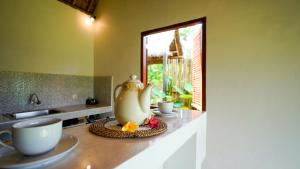 a kitchen with a tea kettle and cups on a counter at D'Penglipuran Jungle House in Susut +32 photos