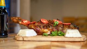 ein Stück Fleisch mit Tomaten auf einem Schneidebrett in der Unterkunft KEDOVO Cottages in Nyeri