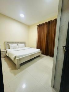 um quarto com uma cama e uma janela em Al Khaleej Plaza Furnished Hotel Apartments em Ajman