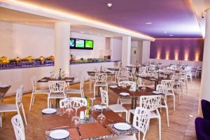 une salle à manger avec des tables et des chaises blanches dans l'établissement Agua Dorada Beach Hotel By Lidotel, à El Agua