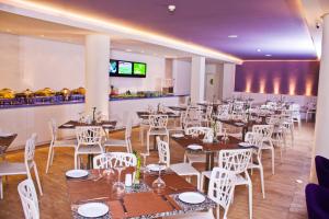 埃爾阿瓜的住宿－Agua Dorada Beach Hotel By Lidotel，用餐室配有桌子和白色椅子