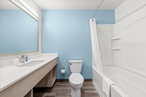 a bathroom with a toilet and a sink and a tub at WoodSpring Suites Oak Ridge Knoxville in Oak Ridge