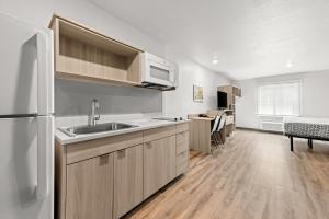 a kitchen with a sink and a white refrigerator at WoodSpring Suites Oak Ridge Knoxville in Oak Ridge