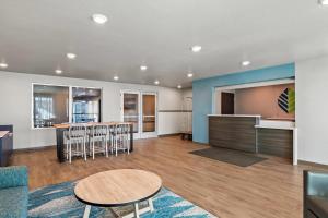 a living room with a table and chairs and a kitchen at WoodSpring Suites Palm Springs - West Palm Beach in Palm Springs