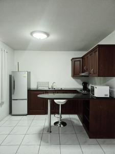 a kitchen with a table and a refrigerator at Townhome 49 in Ban Nong Pru
