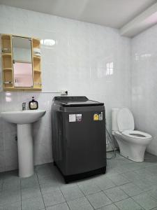 a white bathroom with a sink and a toilet at Townhome 49 in Ban Nong Pru