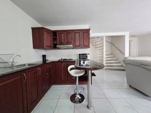 a kitchen with wooden cabinets and a table with a chair at Townhome 49 in Ban Nong Pru +4 photos