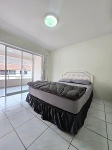 a large bed in a bedroom with a large window at Townhome 49 in Ban Nong Pru