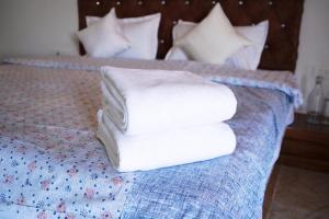 a stack of towels sitting on a bed at Narayani Bag Resort & Restaurant  +41 photos