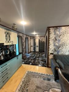 Una sala de estar con un sofá y una cocina. en Nadir ailevi hotel, 