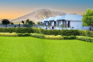 a large green yard with a building in the background at Narayani Bag Resort & Restaurant 