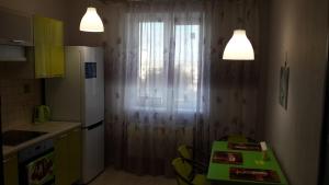 a kitchen with a white curtain and a table with chairs at Apartment Sofia 1 in Volgograd